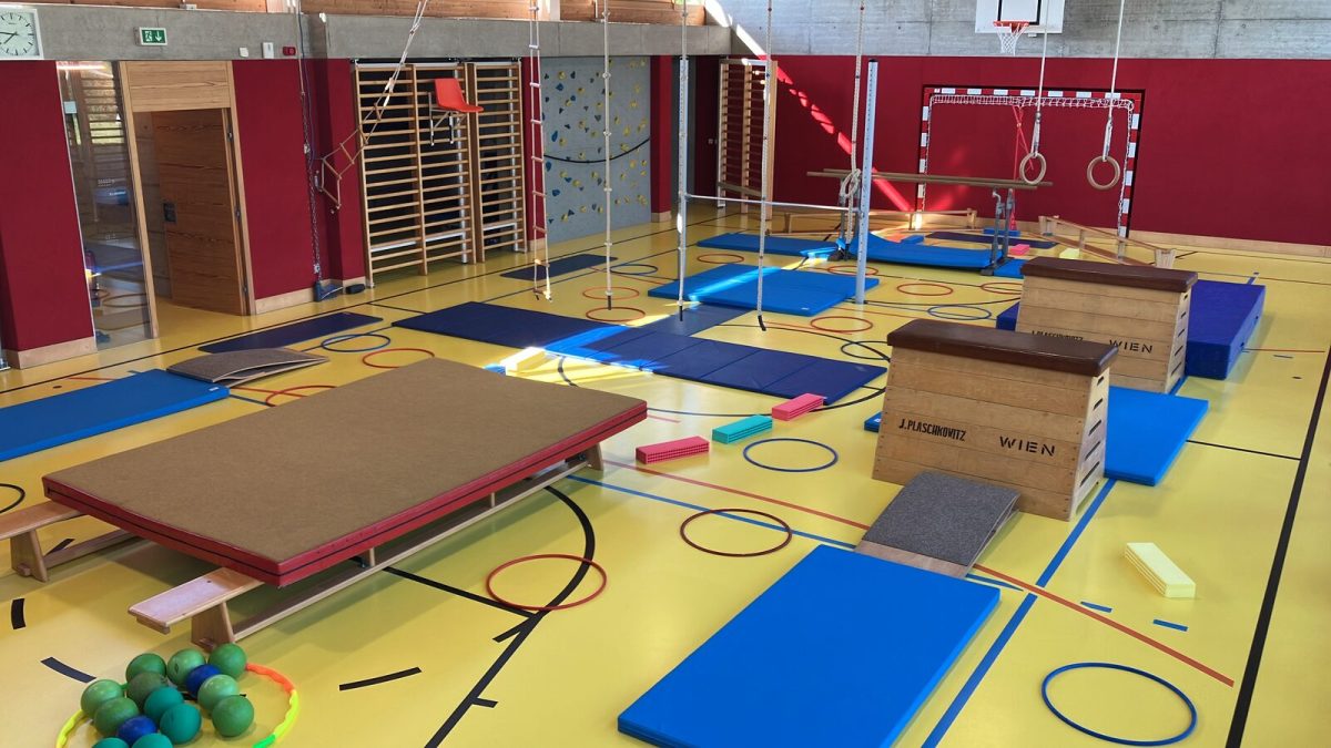 Turnhalle mit aufgebauten Geräten: Kasten, Matten und Reifen